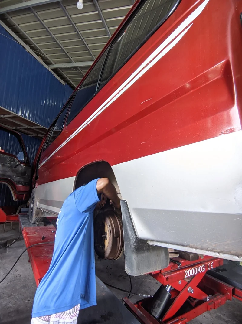 CASAMOTO technician working at the wheel of a red and silver van on a lift