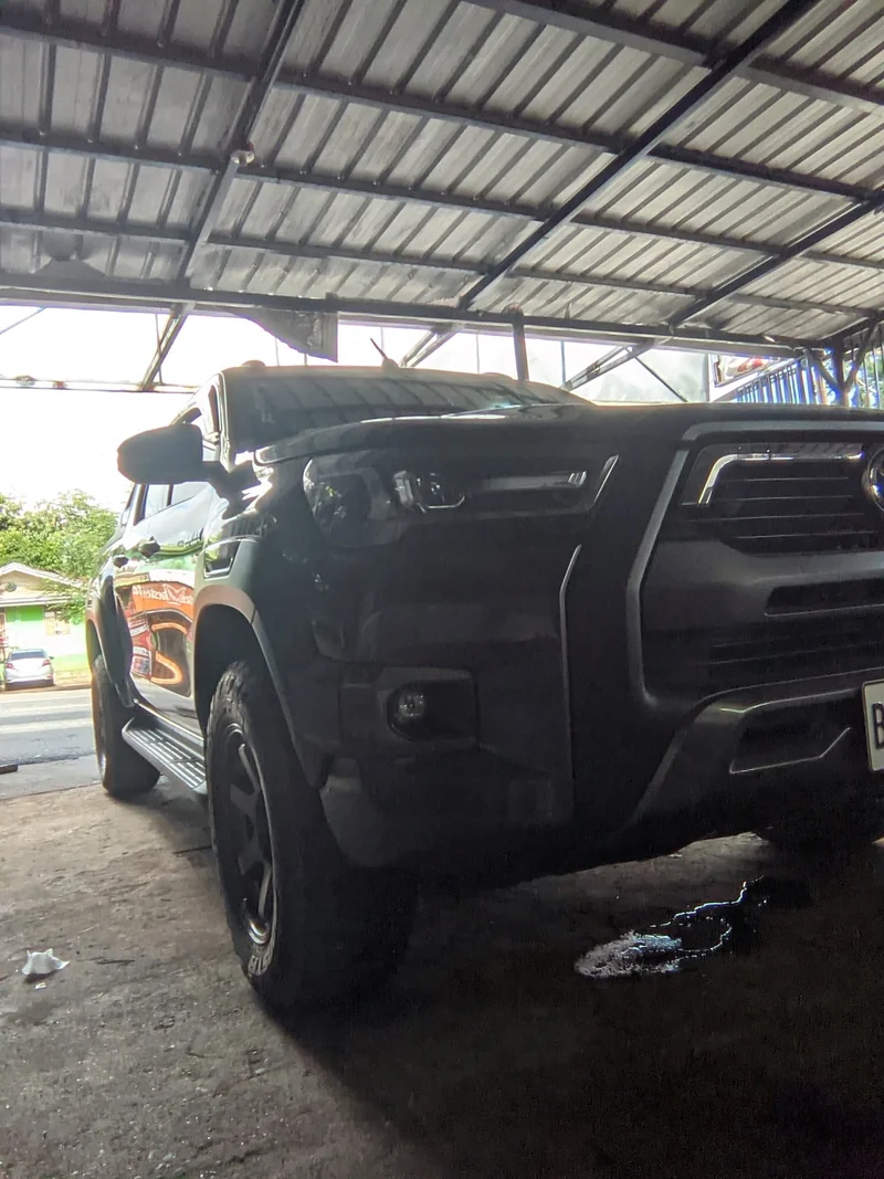 Dark pickup with its bonnet open inside the CASAMOTO service bay