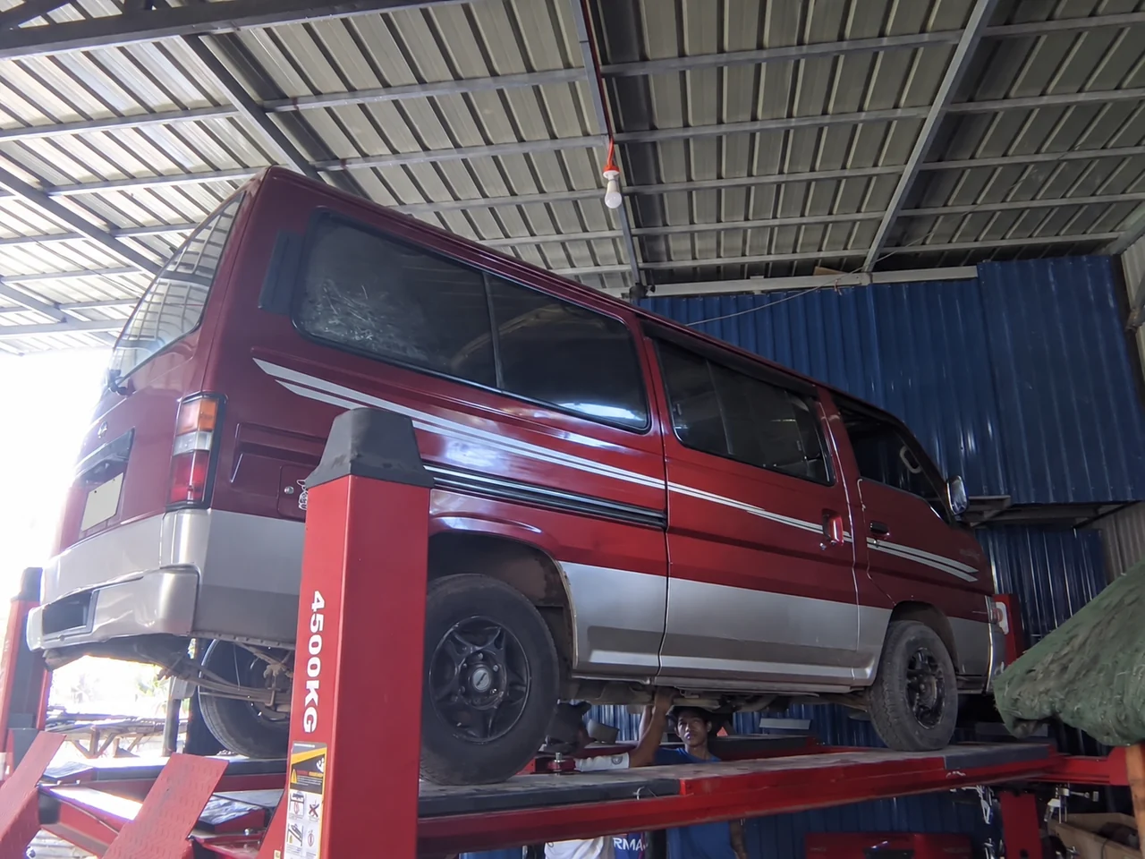 Red and silver van raised on the CASAMOTO workshop lift